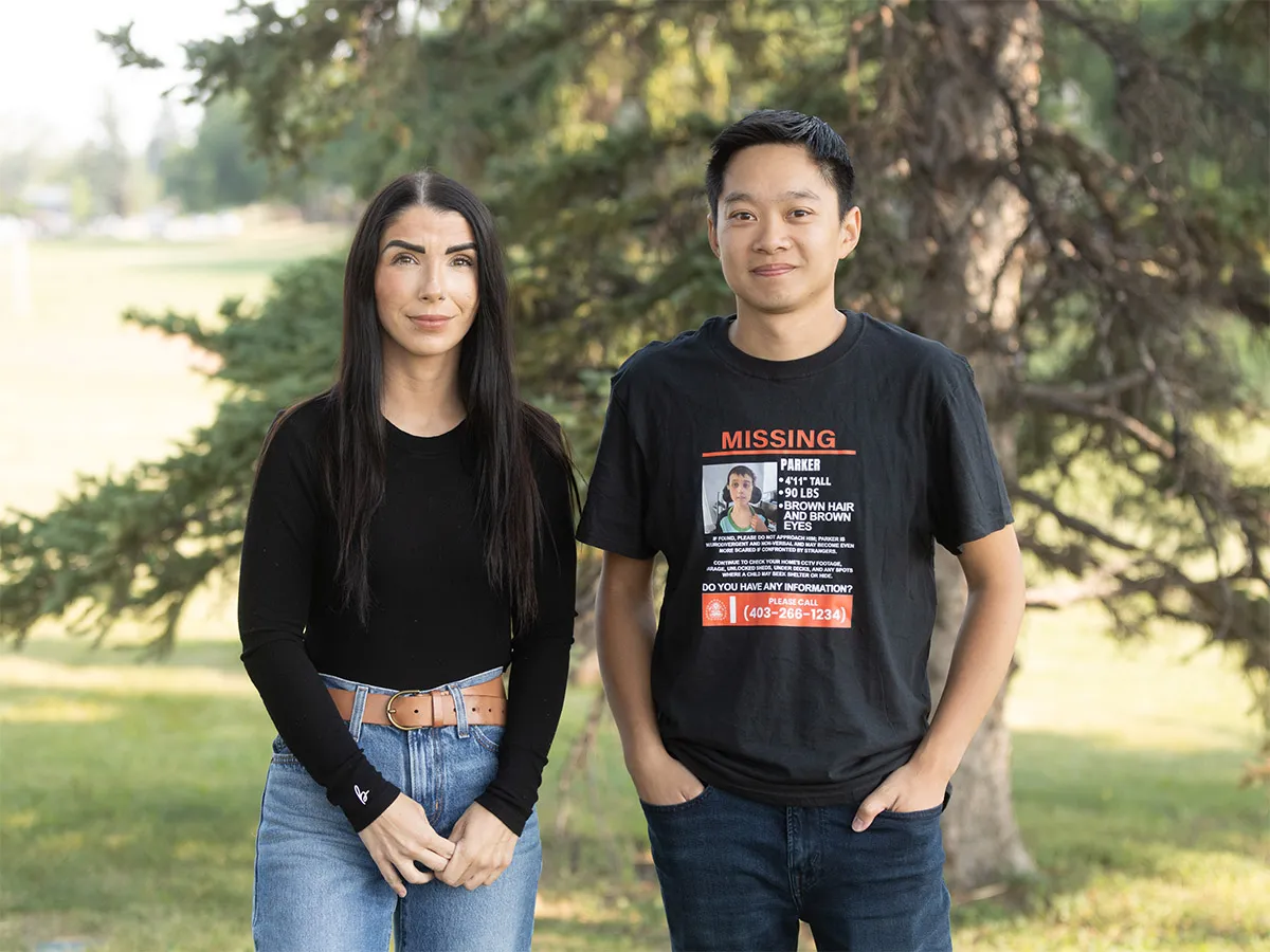 Jennifer Ball, founder of the Indigo Alert Canada petition, and Steven Phan, campaign volunteer, standing together outdoors. Steven is wearing a t-shirt printed with Parker Wells' missing-person poster.